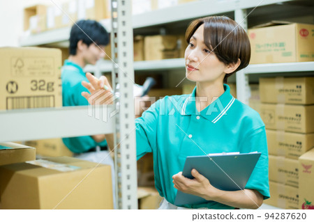 Young woman managing inventory in a warehouse Young woman managing inventory in a warehouse 94287620