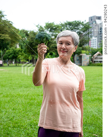 Happy senior asian woman smiling and standing with organic fruits and vegetables in hands enjoying nature fresh air in park, suitable for elderly healthy eating or vegetarian food Happy senior asian woman smiling and standing with organic fruits and vegetables in hands enjoying nature fresh air in park, suitable for elderly healthy eating or vegetarian food 94290243