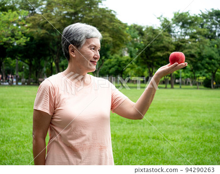 享受亞洲女性微笑站的歡樂娛樂,手工製作的水果,在公園裡享受大自然的清新空氣,適合老年人的健康飲食理念。 享受亞洲女性微笑站的歡樂娛樂,手工製作的水果,在公園裡享受大自然的清新空氣,適合老年人的健康飲食理念。 94290263