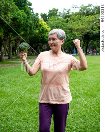 Happy senior asian woman smiling and standing with organic fruits and vegetables in hands enjoying nature fresh air in park, suitable for elderly healthy eating or vegetarian food Happy senior asian woman smiling and standing with organic fruits and vegetables in hands enjoying nature fresh air in park, suitable for elderly healthy eating or vegetarian food 94290318