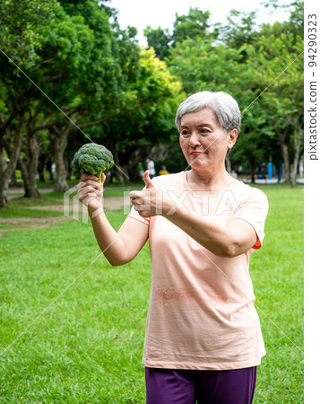 Happy senior asian woman smiling and standing with organic fruits and vegetables in hands enjoying nature fresh air in park, suitable for elderly healthy eating or vegetarian food Happy senior asian woman smiling and standing with organic fruits and vegetables in hands enjoying nature fresh air in park, suitable for elderly healthy eating or vegetarian food 94290323