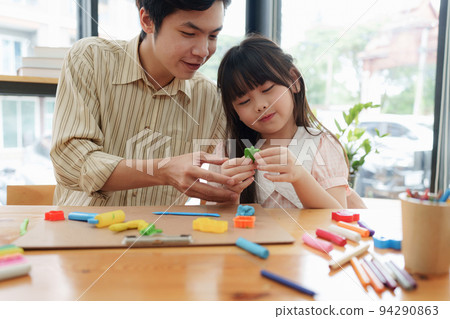 Adorable little girl and father playing with colorful plasticine. Handmade skills training 94290863