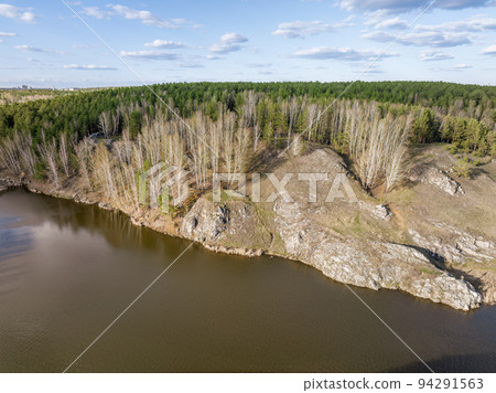 Beauriful sunset view along the Iset river and rocks near Kamensk-Uralskiy. A scenic sunset at the river. Kamensk-Uralskiy, Sverdlovsk region, Ural mountains, Russia. Aerial view 94291563