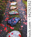 Stepping stones and maple leaves wet in the rain 94292362