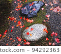 Stepping stones and maple leaves wet in the rain 94292363