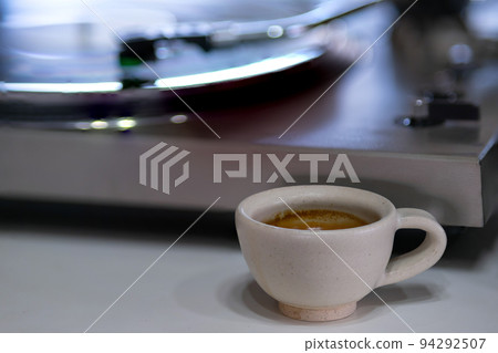 A Cup of Espresso Shot Coffee with a blur background of record turntable A Cup of Espresso Shot Coffee with a blur background of record turntable 94292507