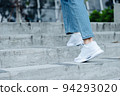 Close up white shoes of woman walking on staire in the outdoor park in sunny day 94293020