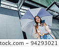 Beautiful Asian woman happiness holding umbrella and listening favourite music on headphones from mobile phone, Happiness relaxation summer in park with music 94293021