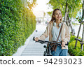 Beautiful Asian woman listening favourite music on headphones from mobile phone, Happiness relaxation summer in park with music riding bicycle in green park. 94293023