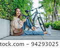 Beautiful Asian woman happiness holding umbrella and listening favourite music on headphones from mobile phone, Happiness relaxation summer in park with music 94293025
