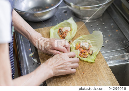 Senior woman making cabbage rolls Senior woman making cabbage rolls 94294036