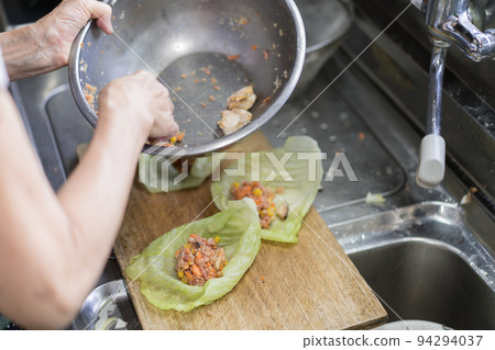 Senior woman making cabbage rolls Senior woman making cabbage rolls 94294037
