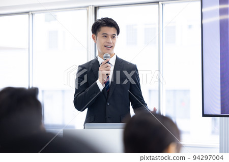 Seminar speaker A man holding a microphone and speaking 94297004