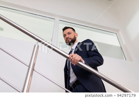 businessman in a business suit climbs the stairs to the top. Career growth concept. 94297179