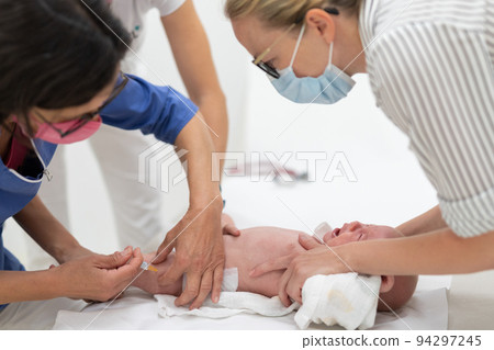 Baby beeing vaccinated by pediatrician in presence of his mother. Preventive vaccination against Diphtheria, whooping cough, tetanus, hepatitis, haemophilus influenzae, pneumococcus, poliomyelitis 94297245