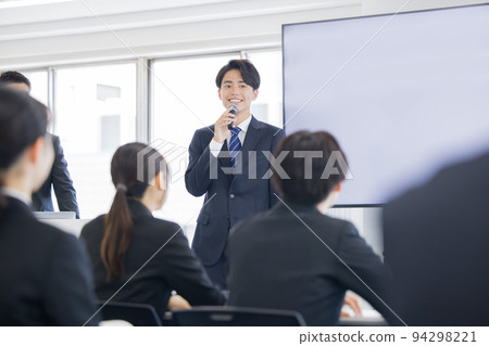 新員工培訓一個年輕人用麥克風說話 新員工培訓一個年輕人用麥克風說話 94298221