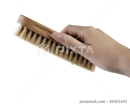 a clothes brush in the female hand a clothes brush in the female hand 94301435