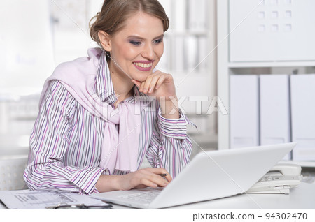 Portrait of a smiling beautiful business woman using a laptop. 94302470