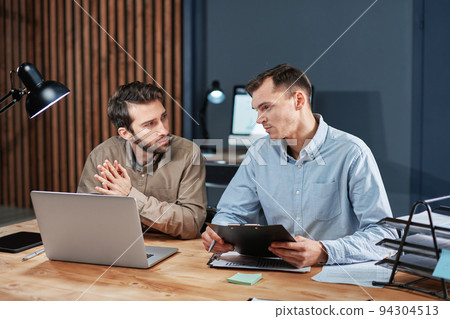 colleagues working on a new project in the night office. 94304513