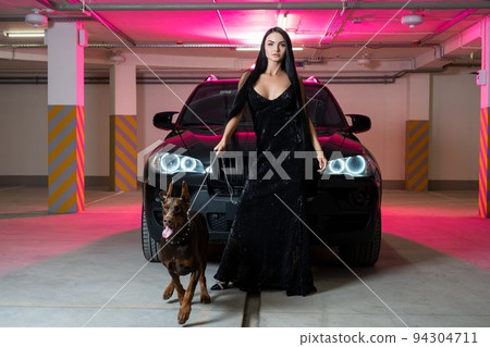 Provocative brunette with brutal dog near car Provocative brunette with brutal dog near car 94304711
