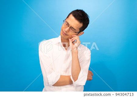 一個男人在思考,左肘放在右臂上,手放在臉頰上 一個男人在思考,左肘放在右臂上,手放在臉頰上 94304713
