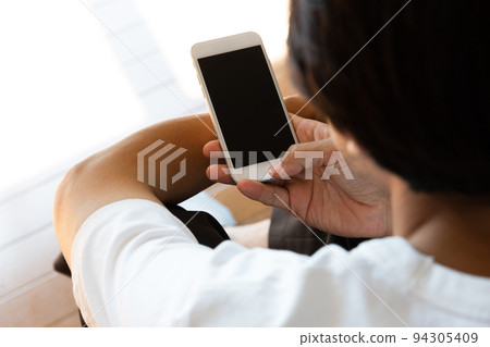 A man operating a smartphone A man operating a smartphone 94305409
