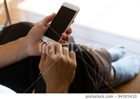 A man operating a smartphone 94305410