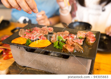 Top view of dice beef on the pan and stove and sprinkle with salt Top view of dice beef on the pan and stove and sprinkle with salt 94305663