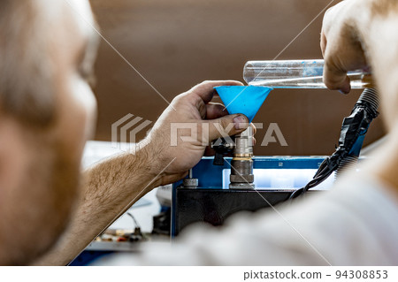 Professional mechanic working on fuel injector cleaning machine in car service Professional mechanic working on fuel injector cleaning machine in car service 94308853