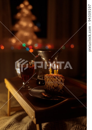 christmas decorations at home, lights garlands on the Christmas tree for new year and Christmas. cake and candles for a birthday christmas decorations at home, lights garlands on the Christmas tree for new year and Christmas. cake and candles for a birthday 94309197