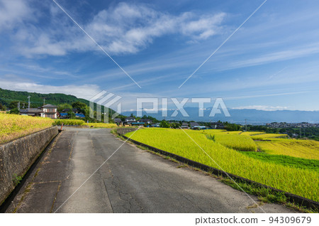 A road through the countryside, the rice terraces of Nakano 94309679