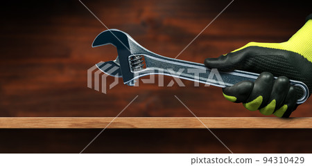 Hand with Protective Work Gloves Holding a Steel Adjustable Wrench Hand with Protective Work Gloves Holding a Steel Adjustable Wrench 94310429
