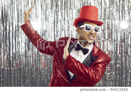Happy funny black man in a red sequin jacket, top hat and sunglasses dancing at a party Happy funny black man in a red sequin jacket, top hat and sunglasses dancing at a party 94311050