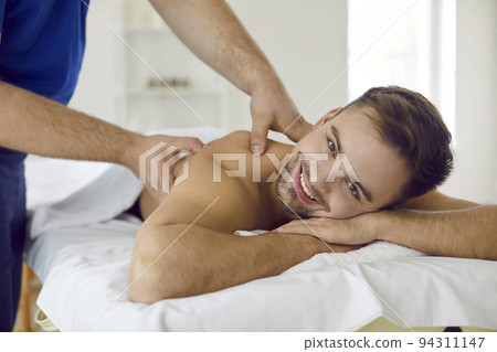 Smiling male client have massage in salon 94311147