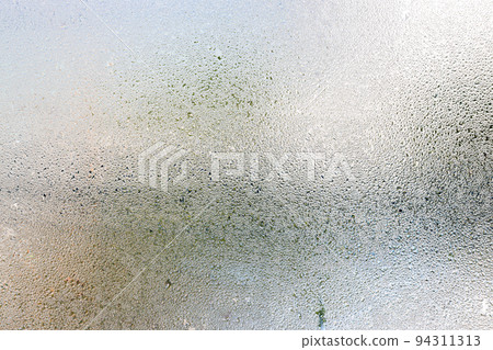 Misted glass, silver rain drops dew drops on transparent glass window Misted glass, silver rain drops dew drops on transparent glass window 94311313