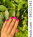 Beautiful gentle manicure. Close-up woman's hand holds a green leaf.  94311341