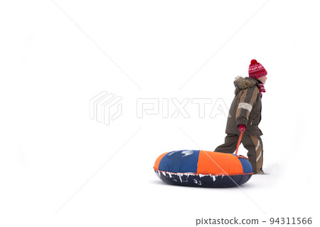 Child in winter. A boy with sledges and cheesecakes is walking in the snow. Child in winter. A boy with sledges and cheesecakes is walking in the snow. 94311566