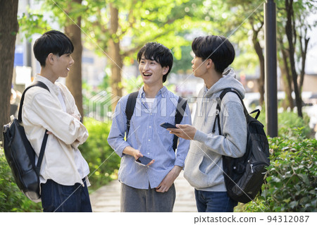 Image of three male college students having a conversation with a smile Image of three male college students having a conversation with a smile 94312087