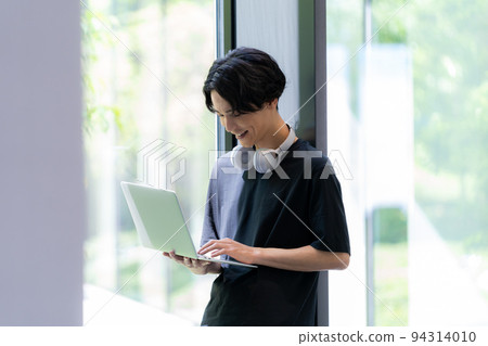 一個拿著電腦的年輕人 由“LINK FOREST”拍攝 94314010