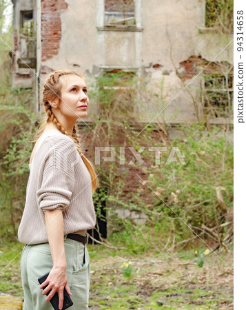 Woman looking at an overgrown abandoned city. Woman sightseeing in an abandoned city. Walk through the abandoned city. Woman looking at an overgrown abandoned city. Woman sightseeing in an abandoned city. Walk through the abandoned city. 94314658