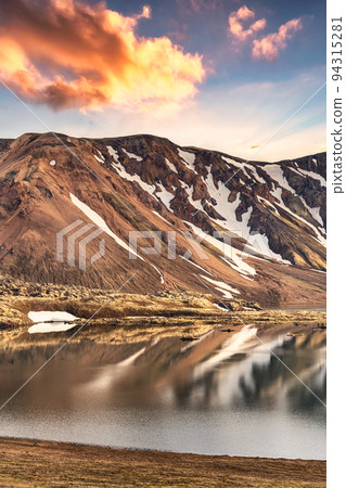 Volcanic mountain range with snow covered and sunset sky in Icelandic highlands on Landmannalaugar at Iceland Volcanic mountain range with snow covered and sunset sky in Icelandic highlands on Landmannalaugar at Iceland 94315281