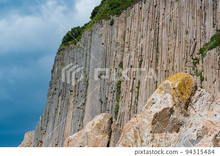 high coastal cliff formed by stone columns, Cape Stolbchaty on the island of Kunashir high coastal cliff formed by stone columns, Cape Stolbchaty on the island of Kunashir 94315484