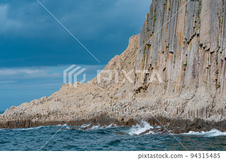 coast of Kunashir Island on Cape Stolbchaty with basalt columned rocks in cloudy weather coast of Kunashir Island on Cape Stolbchaty with basalt columned rocks in cloudy weather 94315485