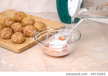 A man pours hot water into a sauce to cook lazy A man pours hot water into a sauce to cook lazy 94316868