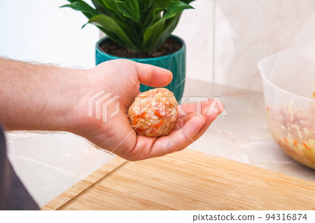A man sculpts lazy cabbage rolls from minced meat A man sculpts lazy cabbage rolls from minced meat 94316874