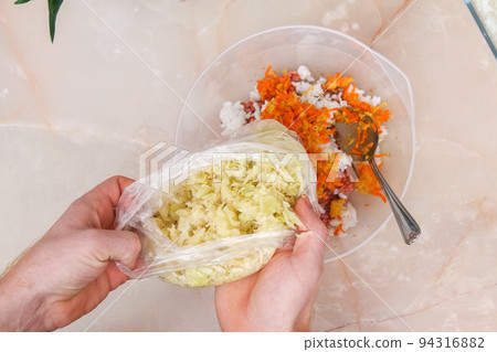 A man adds frozen cabbage to the minced meat for 94316882