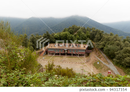 Foggy landscape with a house in the mountains 94317354