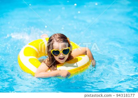 Child in swimming pool on ring toy. Kids swim. 94318177