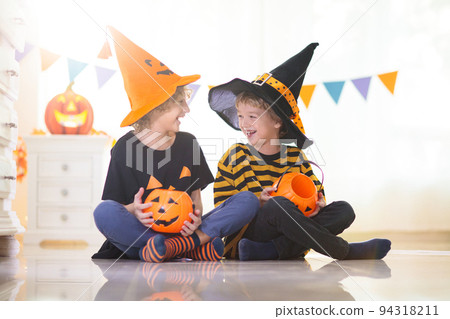 Kids in witch costume on Halloween trick or treat 94318211