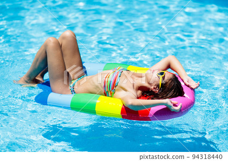 Woman in swimming pool on float. Female swimming. 94318440